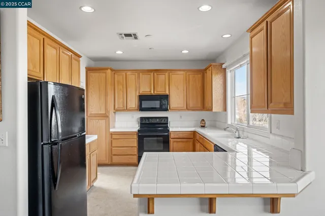 a kitchen with a refrigerator a sink and cabinets
