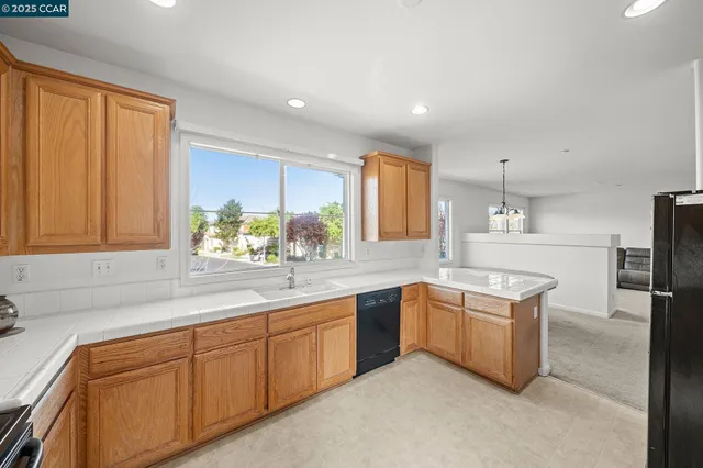 a kitchen with white cabinets and sink