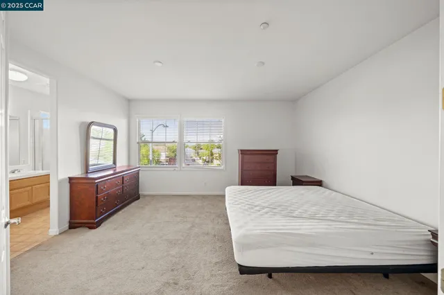 a spacious bedroom with a large bed and dresser