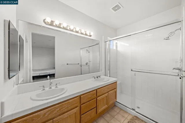 a bathroom with a double vanity sink and mirror