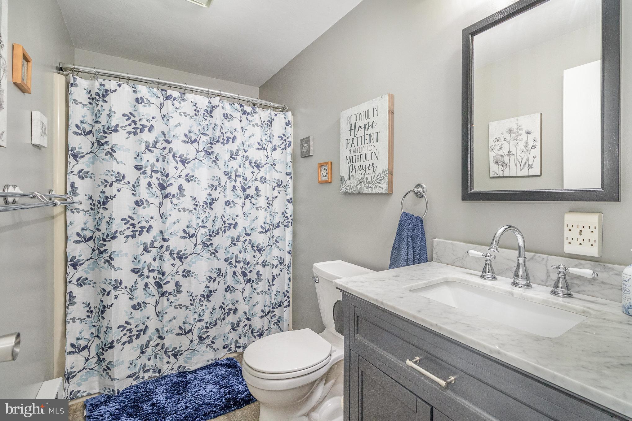 15 Penn Circle Hanover, PA 17331 - Photo 11 of 32 a bathroom with a granite countertop toilet a sink a mirror and a shower curtain