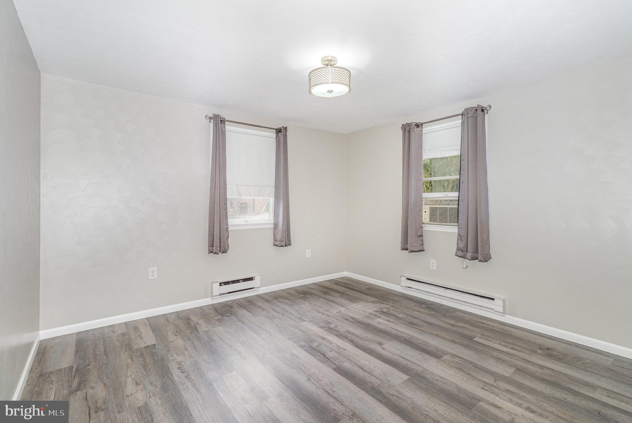 15 Penn Circle Hanover, PA 17331 - Photo 15 of 32 an empty room with wooden floor and windows