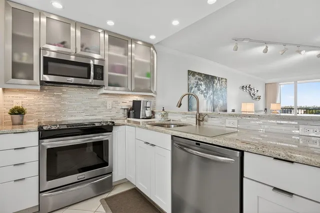 a kitchen with stainless steel appliances granite countertop a stove microwave and sink