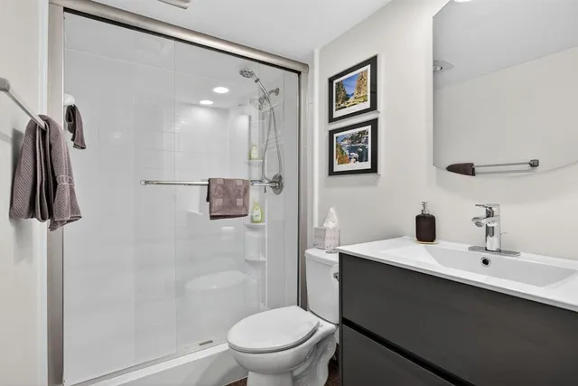 a bathroom with a sink a toilet and shower