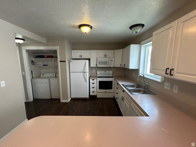 432 Spring Lane Logan, UT 84341 - Photo 11 of 22 Kitchen featuring white cabinetry, white appliances, light countertops, washer and dryer, and dark wood-style floors
