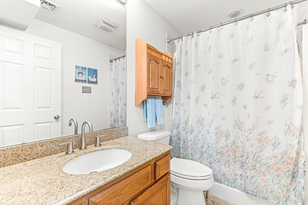 112 Abington Road, Unit 112 Danvers, MA 01923 - Photo 16 of 38 a bathroom with a granite countertop sink a toilet and a mirror