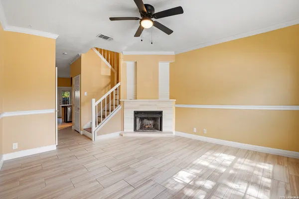 a view of an empty room with window and wooden floor