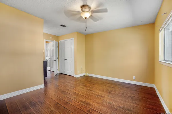 a view of an empty room with a window and a ceiling fan
