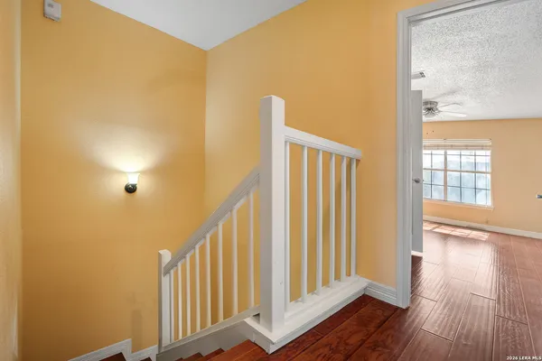a view of a hallway with wooden floor and staircase