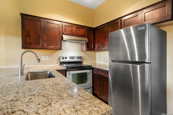 a kitchen with stainless steel appliances granite countertop a refrigerator and a sink