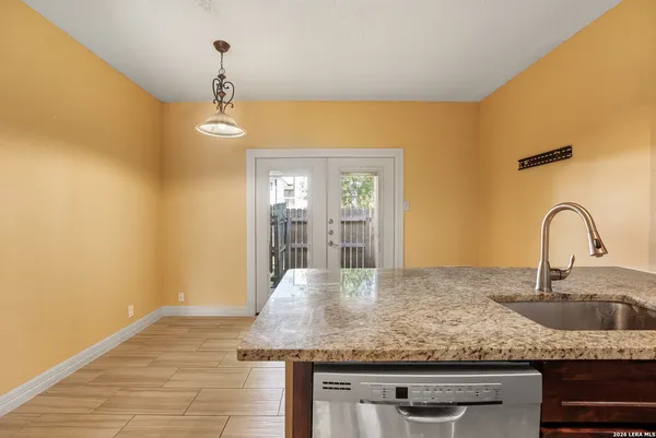 a view of a kitchen counter top a sink and dishwasher with wooden floor