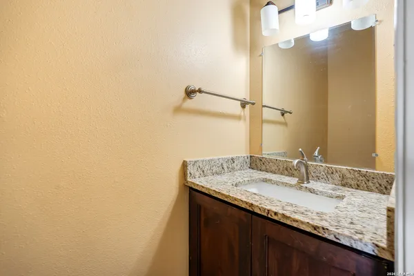a bathroom with a granite countertop sink and a mirror