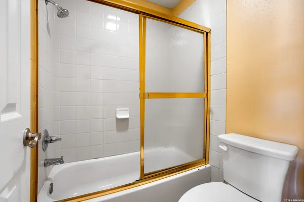 a bathroom with a granite countertop toilet and a bathtub