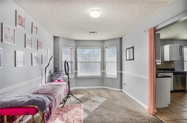 a bed room with a bed and a view of kitchen