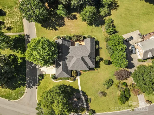 an aerial view of a house with a yard swimming pool and outdoor seating