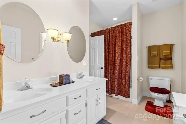 a bathroom with a double vanity sink mirror and shower