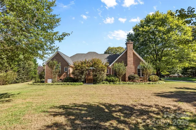 a front view of a house with a yard and trees
