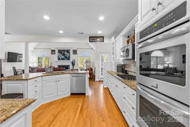 a large kitchen with stainless steel appliances lots of counter space and wooden floor