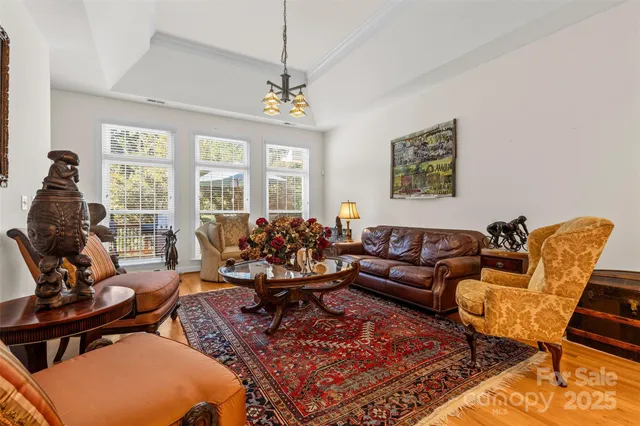 a living room with furniture a chandelier and a rug