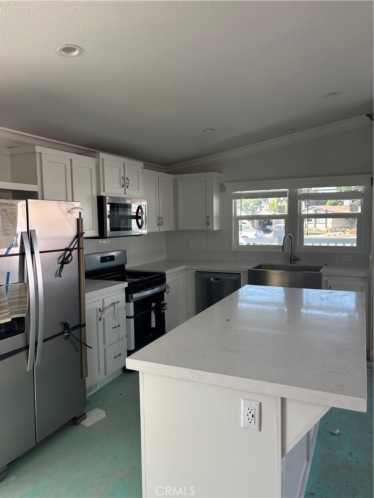 10550 Dunlap Crossing Road, Unit 27 Whittier, CA 90606 - Photo 9 of 13 a kitchen with kitchen island a counter top space a sink and appliances