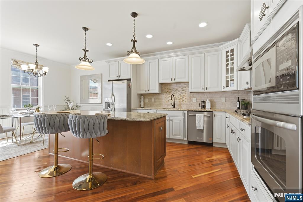 14 Gable Walk Livingston, NJ 07039 - Photo 13 of 41 a kitchen with kitchen island granite countertop wooden floors and white cabinets