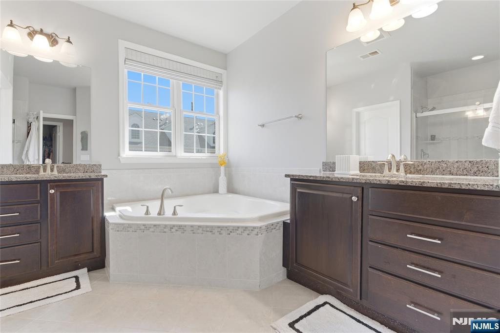 14 Gable Walk Livingston, NJ 07039 - Photo 25 of 41 a bathroom with a granite countertop bathtub sink vanity and mirror