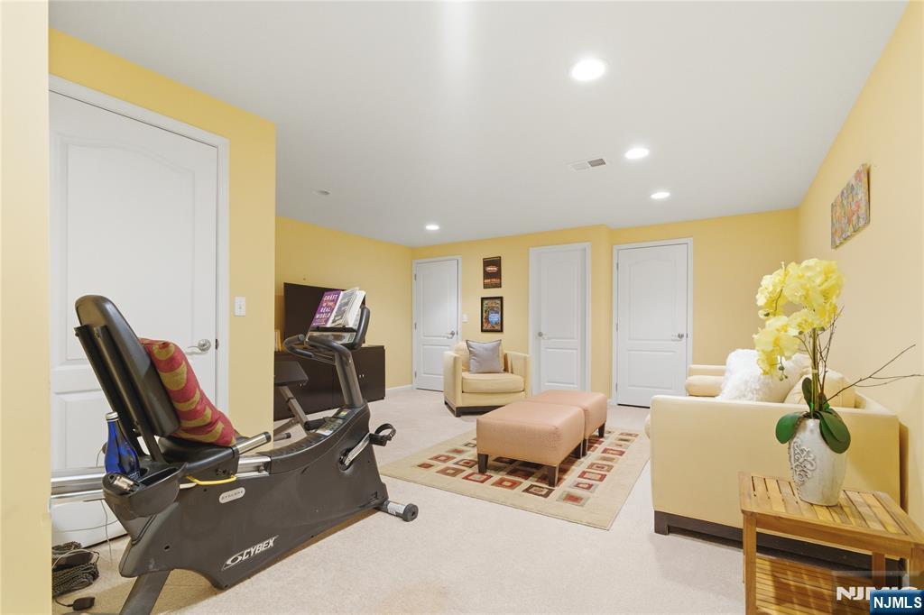 14 Gable Walk Livingston, NJ 07039 - Photo 34 of 41 a living room with furniture gym equipment and a flat screen tv