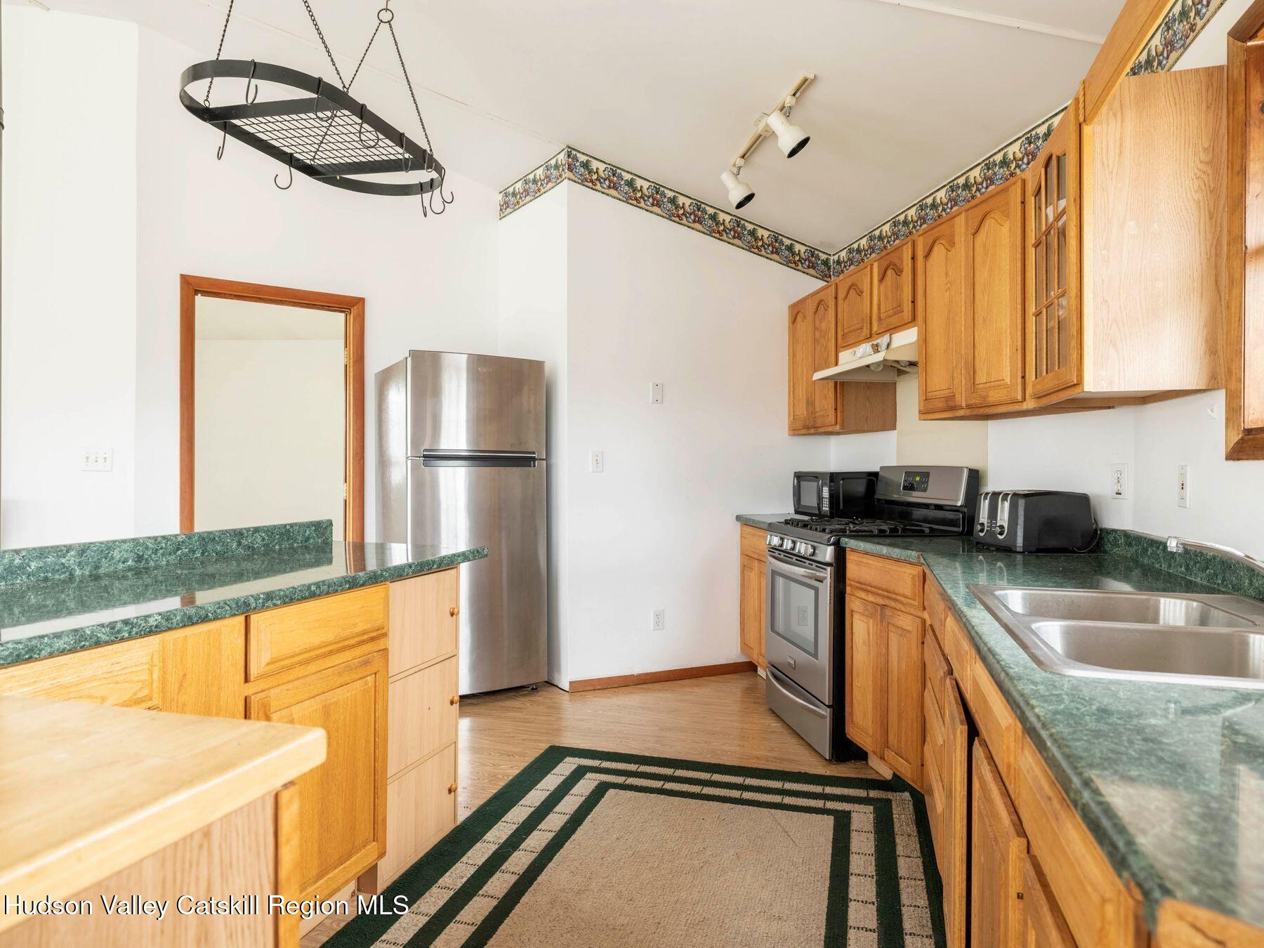 215 Siam Road Windham, NY 12496 - Photo 32 of 65 a kitchen with stainless steel appliances granite countertop a sink a stove and a refrigerator