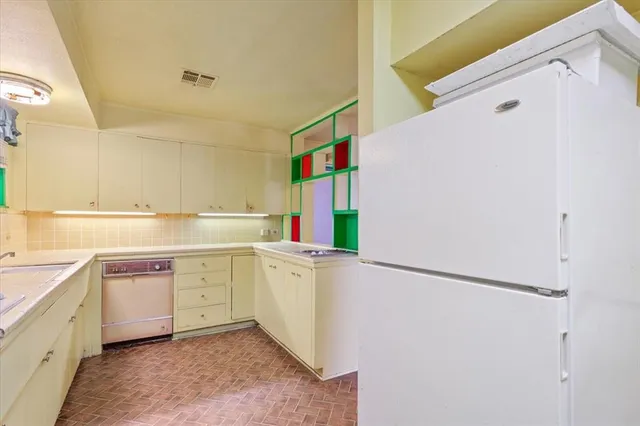 a kitchen with a sink a refrigerator and cabinets