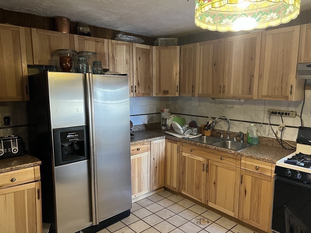 90 Forbes Street Boston, MA 02130 - Photo 11 of 22 a kitchen with stainless steel appliances granite countertop a refrigerator a sink and white cabinets