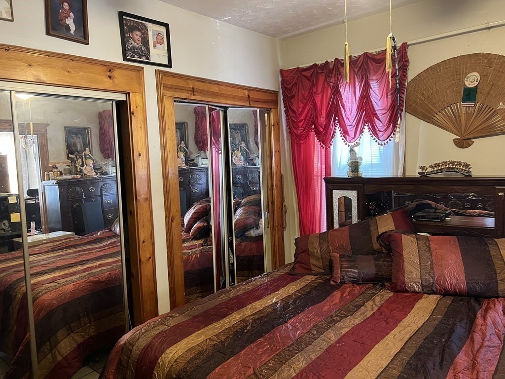 90 Forbes Street Boston, MA 02130 - Photo 14 of 22 a bedroom with a bed and dresser with mirror