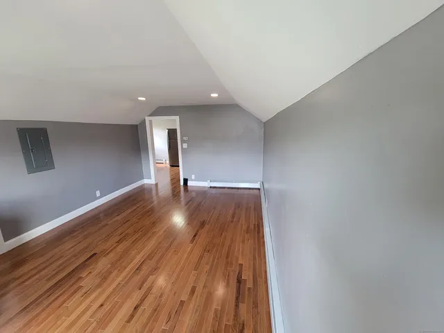 a view of empty room with wooden floor