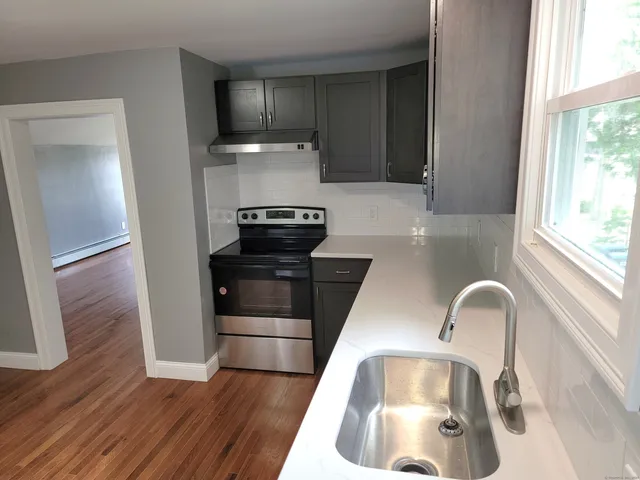 a kitchen with granite countertop a refrigerator and a sink