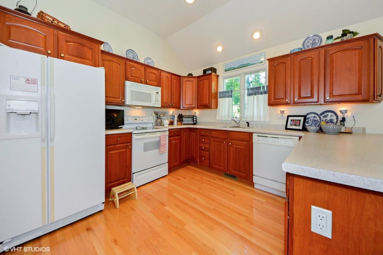 92 Falling Leaf Lane Osterville, MA 02655 - Photo 3 of 15 a kitchen with stainless steel appliances granite countertop wooden cabinets a sink and a stove