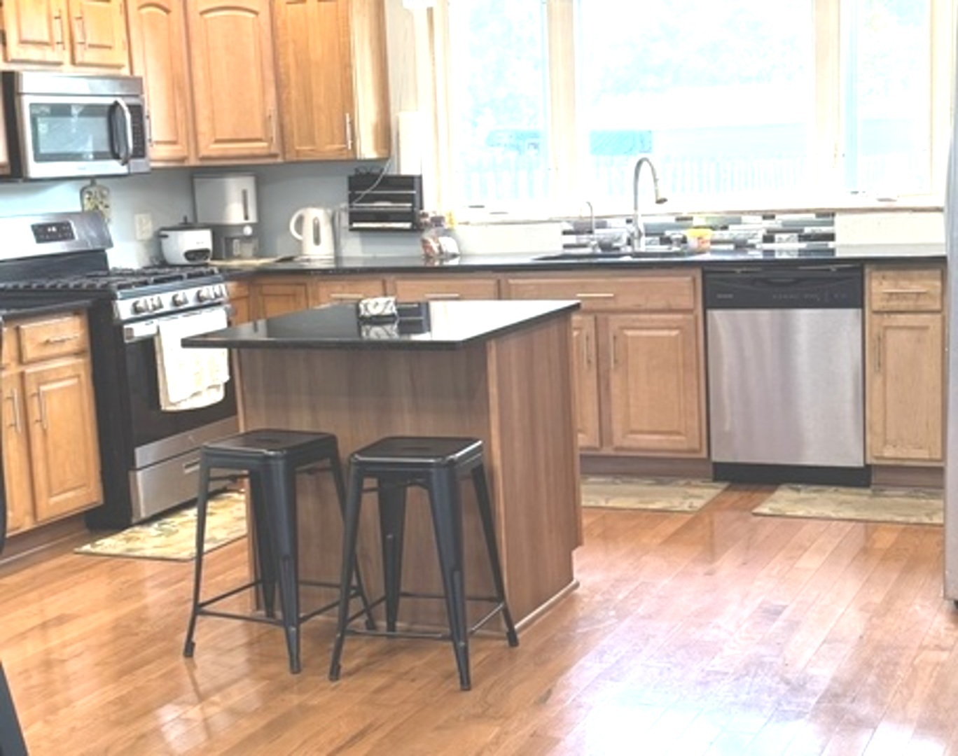 307 Mills Road Joliet, IL 60433 - Photo 3 of 22 a kitchen with stainless steel appliances granite countertop a stove a sink and a microwave