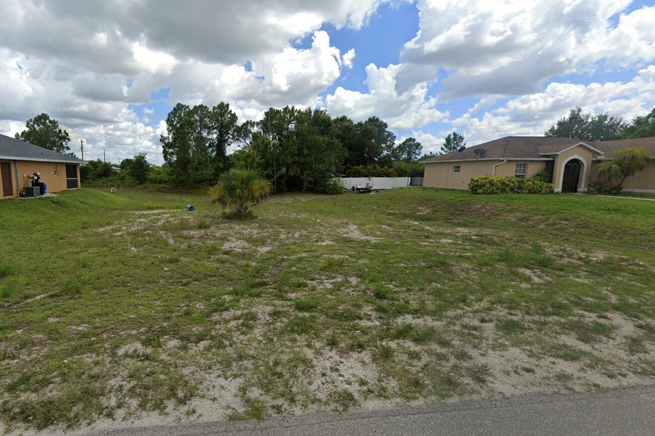 a view of a big yard with large trees