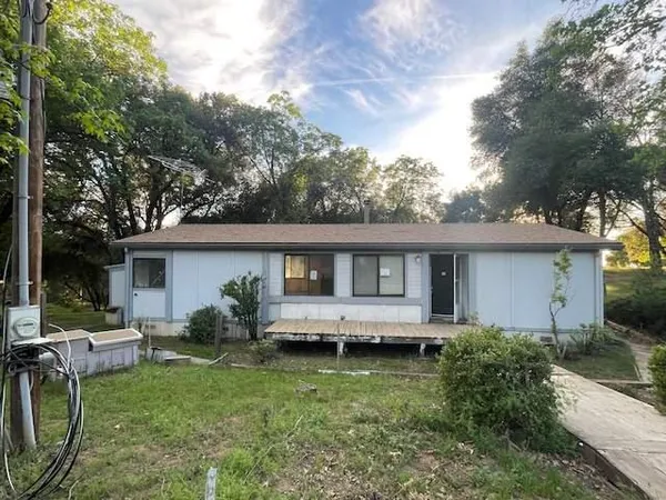 a view of a house with backyard sitting area and garden