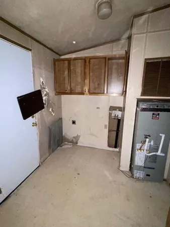 a view of an empty room with a kitchen