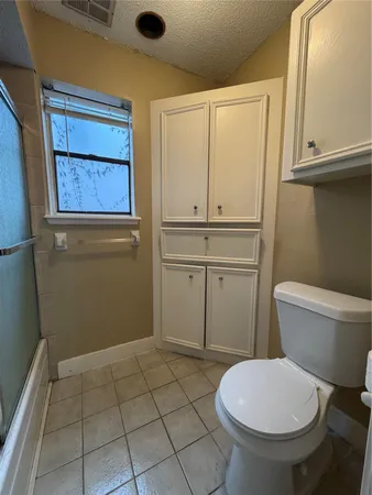 a bathroom with a toilet a sink and a window