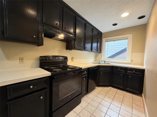 a kitchen with a sink and a stove top oven