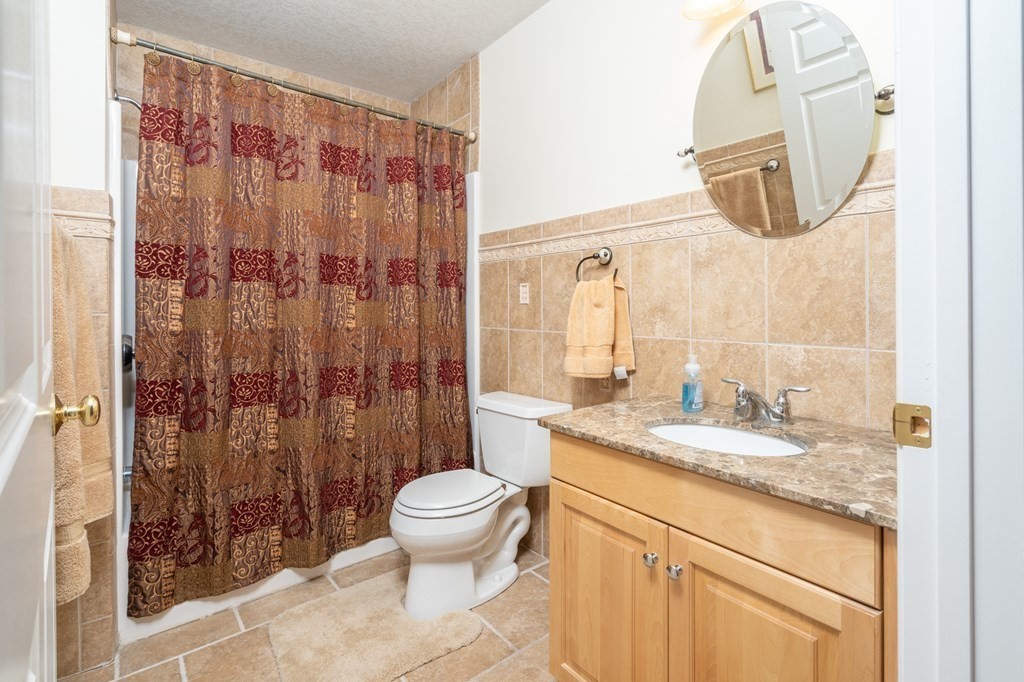 46 Palmer Road, Unit 25 Monson, MA 01057 - Photo 22 of 29 a bathroom with a granite countertop sink a toilet and a mirror