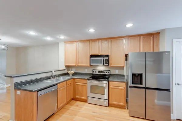 a kitchen with stainless steel appliances granite countertop a refrigerator stove microwave and sink