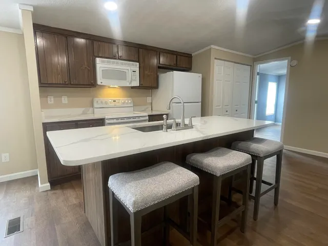 a kitchen with a sink cabinets and wooden floor