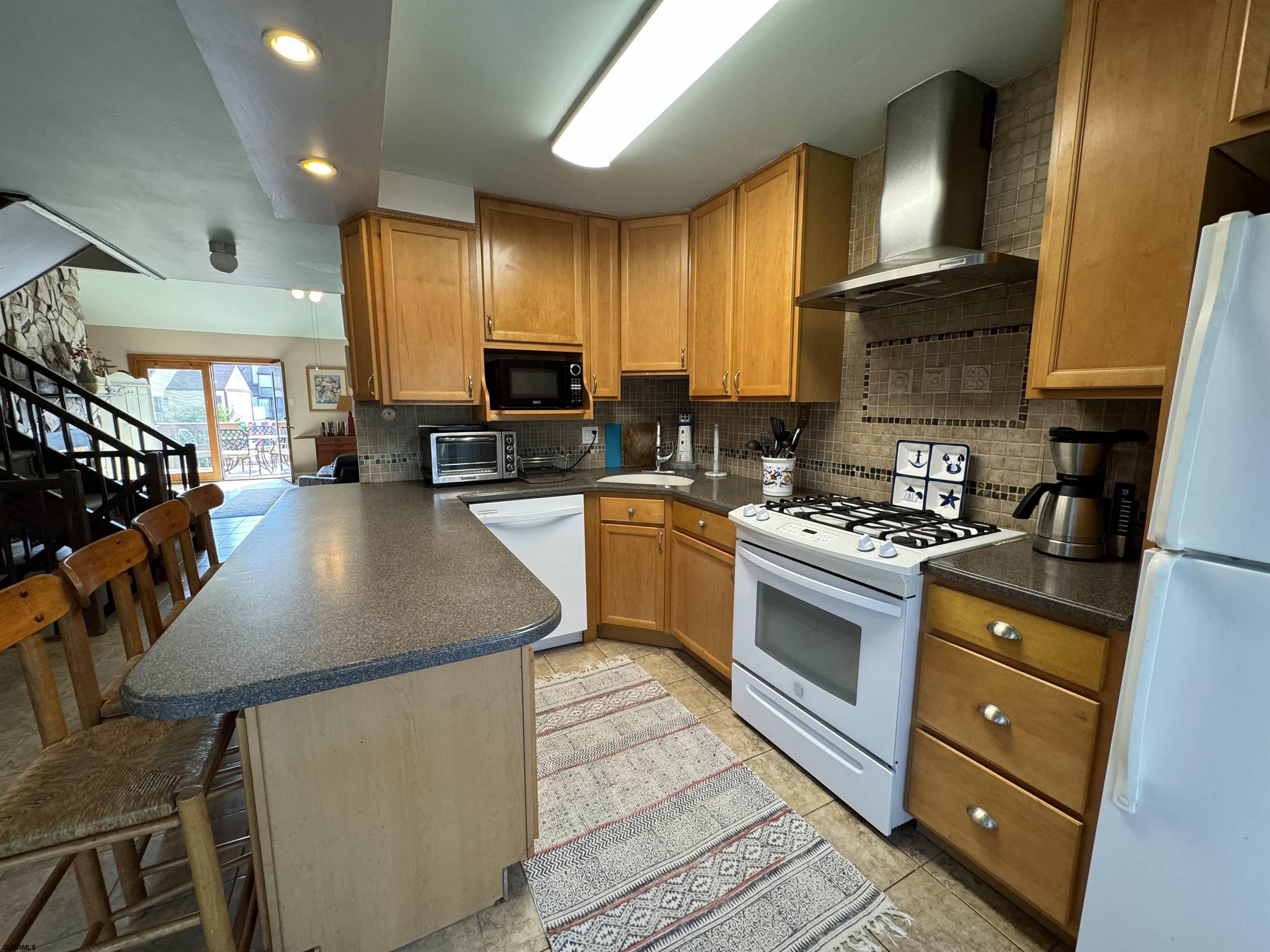 25 Beacon Lane Brigantine, NJ 08203 - Photo 21 of 36 a kitchen with stainless steel appliances granite countertop a sink a stove and cabinets