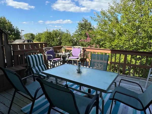 a balcony with wooden floor and outdoor seating