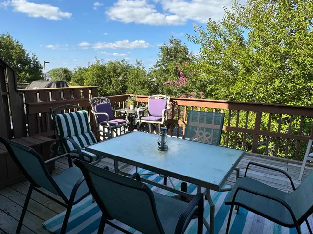 a balcony with wooden floor and outdoor seating