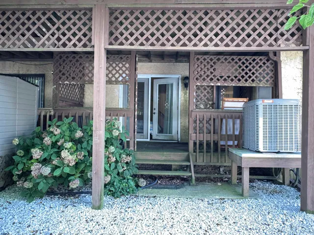 a porch with a bench and potted plants