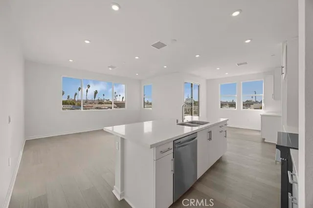 a large kitchen with stainless steel appliances a large counter top a stove and a refrigerator