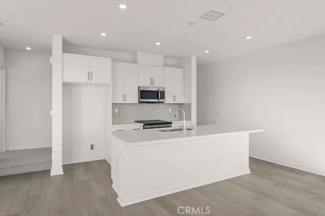 a kitchen with stainless steel appliances a refrigerator sink and microwave