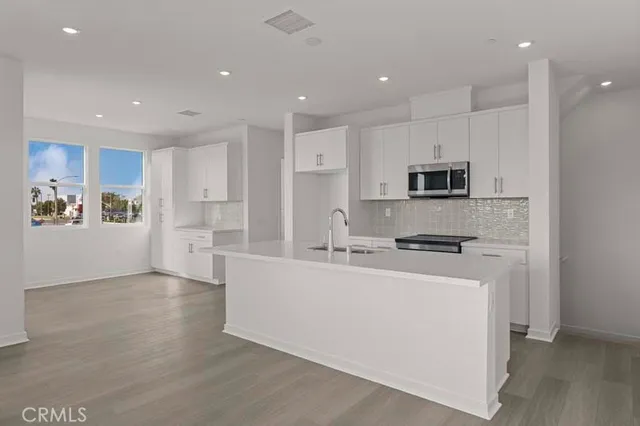 a kitchen with stainless steel appliances a refrigerator stove microwave and cabinets